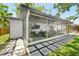 Spacious screened patio featuring an exercise area, seating, and pavers leading to yard at 1313 W Carissa Ct, Tampa, FL 33604