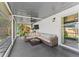 Relaxing screened patio with wicker furniture, overhead fan, and sliding glass doors at 1313 W Carissa Ct, Tampa, FL 33604