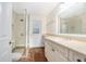 Bathroom featuring a tiled shower with glass door, white vanity, and tile floors at 13310 Golf Crest Cir, Tampa, FL 33618