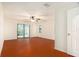 Bedroom with hardwood floors, ceiling fan, closet, and sliding glass doors to the backyard at 13310 Golf Crest Cir, Tampa, FL 33618