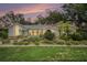 Well-maintained single-story home at dusk featuring manicured landscaping and updated windows at 13310 Golf Crest Cir, Tampa, FL 33618