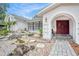 Inviting front entrance featuring an arched entryway, rock garden and meticulously maintained landscape at 13310 Golf Crest Cir, Tampa, FL 33618