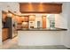 Modern kitchen featuring wood cabinets, stainless steel appliances, tile floors, and a breakfast bar at 13310 Golf Crest Cir, Tampa, FL 33618