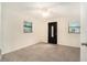 Cozy living room with tiled floors, dark front door, and natural light from two windows at 13310 Golf Crest Cir, Tampa, FL 33618