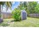 Backyard features privacy fence and storage shed surrounded by lush green grass and tropical foliage at 14105 Farmington Blvd, Tampa, FL 33625