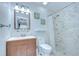 Bright bathroom with a modern vanity, toilet, and tiled walk-in shower, complemented by neutral decor at 14105 Farmington Blvd, Tampa, FL 33625