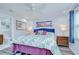 Comfortable bedroom featuring a large bed with tropical bedding, wood-look floors, with a bathroom visible at 14105 Farmington Blvd, Tampa, FL 33625
