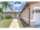 Inviting home exterior with a walkway leading to the front door and lush tropical landscaping at 14105 Farmington Blvd, Tampa, FL 33625