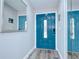 Stylish entryway features a bright blue front door, modern flooring, and a sleek mirror at 14105 Farmington Blvd, Tampa, FL 33625
