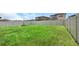 Large, fenced backyard with lush green grass, offering ample space for recreation and relaxation at 1613 Cabbage Key Dr, Ruskin, FL 33570
