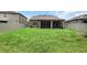 Expansive backyard featuring green grass, a privacy fence, and a view of the home's back exterior at 1613 Cabbage Key Dr, Ruskin, FL 33570