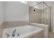 Bathroom featuring a soaking tub and a glass-enclosed shower with neutral tile at 1613 Cabbage Key Dr, Ruskin, FL 33570