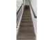 Carpeted staircase with dark wood railing and wrought iron balusters at 1613 Cabbage Key Dr, Ruskin, FL 33570