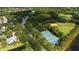 Aerial view of community tennis courts, a park and green space surrounded by mature trees at 17735 Oak Bridge St, Tampa, FL 33647