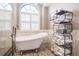 Bright bathroom featuring tub and open shelving with towels at 17735 Oak Bridge St, Tampa, FL 33647
