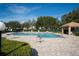 Community pool with lounge chairs and shaded cabana surrounded by greenery and beautiful skies at 17735 Oak Bridge St, Tampa, FL 33647