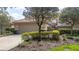 Home exterior with well-kept landscaping, mature trees, and a two-car garage at 17735 Oak Bridge St, Tampa, FL 33647