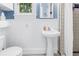 Charming bathroom featuring a pedestal sink, wainscoting, and classic black and white tile at 1822 1St Se St, St Petersburg, FL 33705