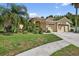 Charming single-story home with well-maintained lawn, landscaping, and mature palm tree at 1835 Fircrest Ct, Wesley Chapel, FL 33543