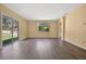 Open living area featuring wood floors, large window, and access to outdoor space at 1835 Fircrest Ct, Wesley Chapel, FL 33543