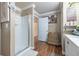 Well-lit bathroom with a glass-enclosed shower and neutral decor with wood style flooring at 18439 Bridle Club Dr # 18439, Tampa, FL 33647