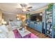 Open living room with a TV, shelving unit, ceiling fan, comfortable seating, and wood flooring at 18439 Bridle Club Dr # 18439, Tampa, FL 33647