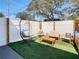 Charming backyard with a hanging chair, patio furniture, and artificial turf at 1887 Springtime Ave, Clearwater, FL 33755