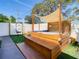 Relax in this backyard with a charming pergola-covered hot tub and egg chair at 1887 Springtime Ave, Clearwater, FL 33755