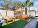 Backyard oasis with a hot tub, outdoor seating, and lush artificial turf at 1887 Springtime Ave, Clearwater, FL 33755