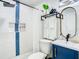 Modern bathroom with a white tiled shower, blue vanity, and stylish fixtures at 1887 Springtime Ave, Clearwater, FL 33755