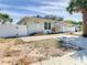 Street view of a light blue single-story home with a white fence and well-manicured yard at 1887 Springtime Ave, Clearwater, FL 33755