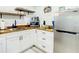 Modern kitchen area with butcher block countertops, white cabinets, and stainless steel appliances at 1887 Springtime Ave, Clearwater, FL 33755
