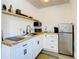 Well-equipped kitchenette featuring white cabinets, butcher block counters, and stainless steel appliances at 1887 Springtime Ave, Clearwater, FL 33755