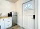 A compact kitchen with a stainless steel fridge and access to the main door at 1887 Springtime Ave, Clearwater, FL 33755