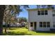 Back of home with a door that opens up to a spacious and well-maintained lawn at 19251 Stone Hedge Dr, Tampa, FL 33647