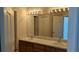 Bright bathroom featuring a dual sink vanity and a large mirror with decorative lighting at 19251 Stone Hedge Dr, Tampa, FL 33647