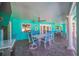 Covered back patio with an outdoor dining set and cozy seating overlooking the pool at 2010 E Vina Del Mar Blvd, St Pete Beach, FL 33706