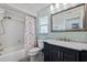 Clean bathroom with a shower-tub combo and navy blue vanity with a marble countertop at 2010 E Vina Del Mar Blvd, St Pete Beach, FL 33706
