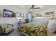 Cozy bedroom featuring natural light from two windows, complemented by a ceiling fan and tropical decor at 2010 E Vina Del Mar Blvd, St Pete Beach, FL 33706