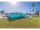 Backyard view of the house, swimming pool, and tropical landscaping at 2010 E Vina Del Mar Blvd, St Pete Beach, FL 33706