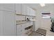 Bright laundry room with extra cabinet space and granite countertops at 2010 E Vina Del Mar Blvd, St Pete Beach, FL 33706