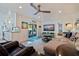 Open-concept living room featuring direct access to the backyard, a ceiling fan, and an adjacent kitchen at 2010 E Vina Del Mar Blvd, St Pete Beach, FL 33706