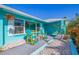 Cozy patio with seating, complemented by vibrant flowers and turquoise accents, offers a relaxing outdoor space at 2010 E Vina Del Mar Blvd, St Pete Beach, FL 33706