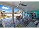 Covered patio featuring an outdoor seating area with ceiling fans overlooking a pool and lush landscaping at 2010 E Vina Del Mar Blvd, St Pete Beach, FL 33706