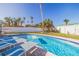 Backyard pool surrounded by lounge chairs and tropical landscaping at 2010 E Vina Del Mar Blvd, St Pete Beach, FL 33706