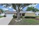 Charming single-story home featuring a large front yard with mature landscaping and a two-car garage at 2209 Kingswood Ln, Brandon, FL 33511