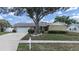 Charming single-story home featuring a large front yard with mature landscaping and a two-car garage at 2209 Kingswood Ln, Brandon, FL 33511
