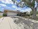 Charming single-story home featuring a large front yard with mature landscaping and a two-car garage at 2209 Kingswood Ln, Brandon, FL 33511