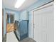 This laundry room features light blue walls, tile floor and modern washer and dryer at 2209 Kingswood Ln, Brandon, FL 33511