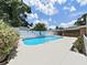 Backyard pool in fenced in yard with a lounge area and beautiful landscaping at 2209 Kingswood Ln, Brandon, FL 33511